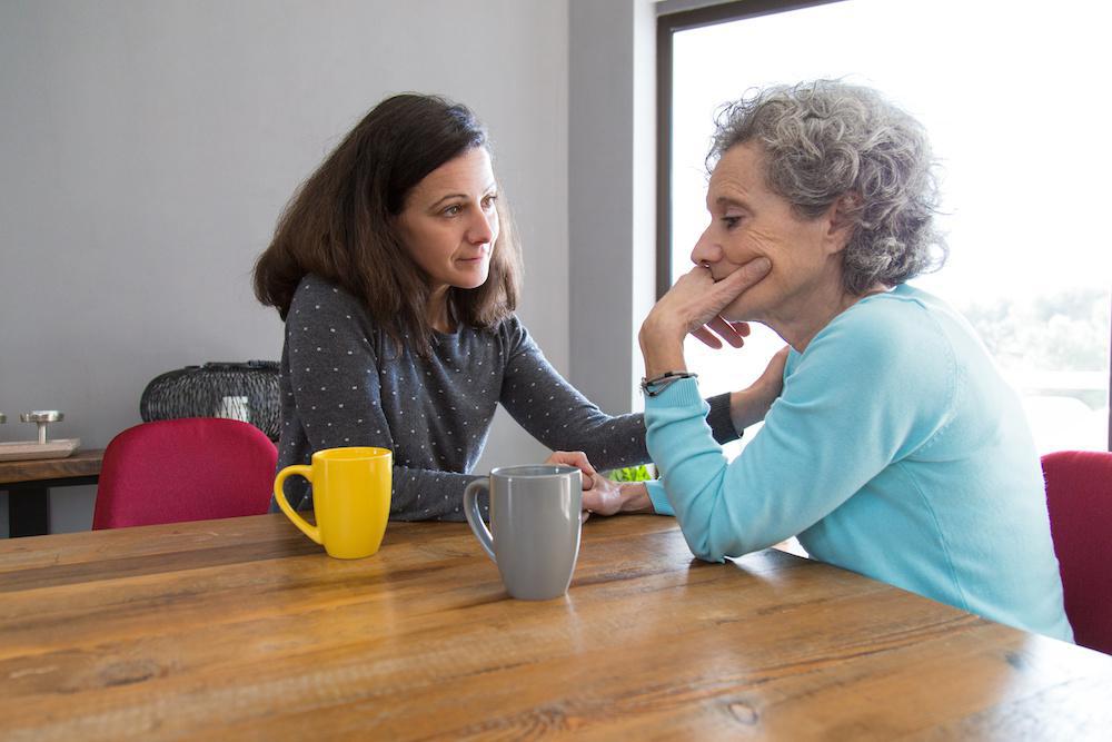 Two people sitting on a porch together — a quiet moment of family support