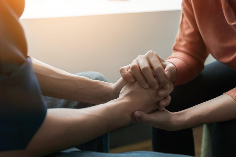 Two people in close conversation, illustrating compassionate family support.