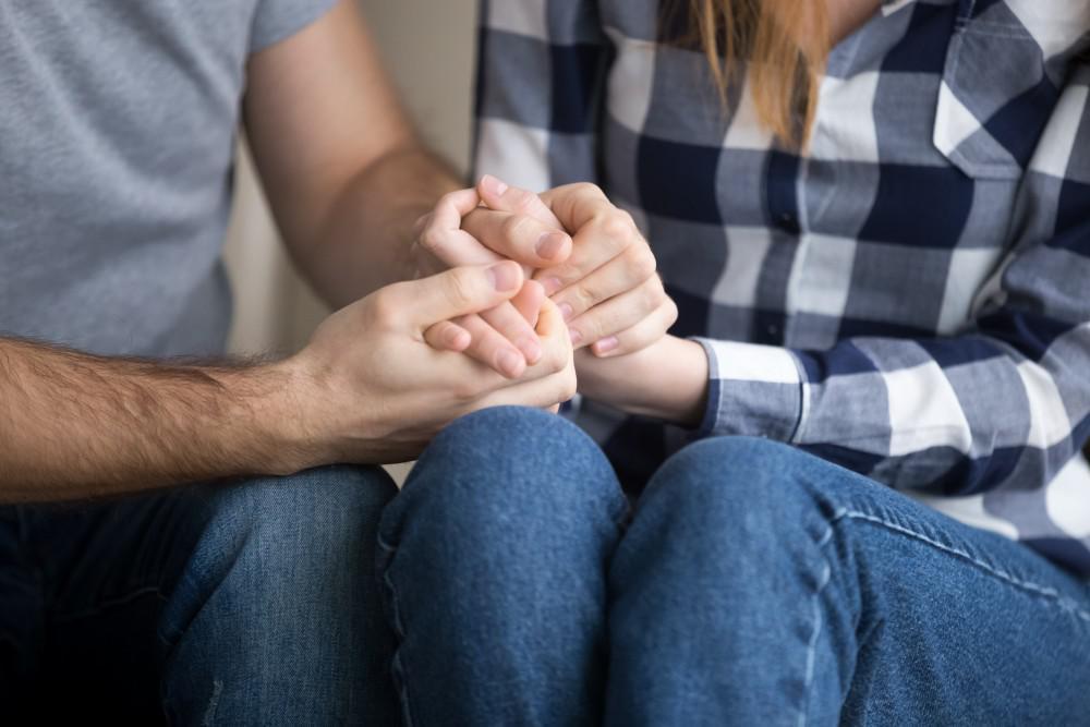 Two people sitting together in conversation, illustrating quiet family support around addiction.