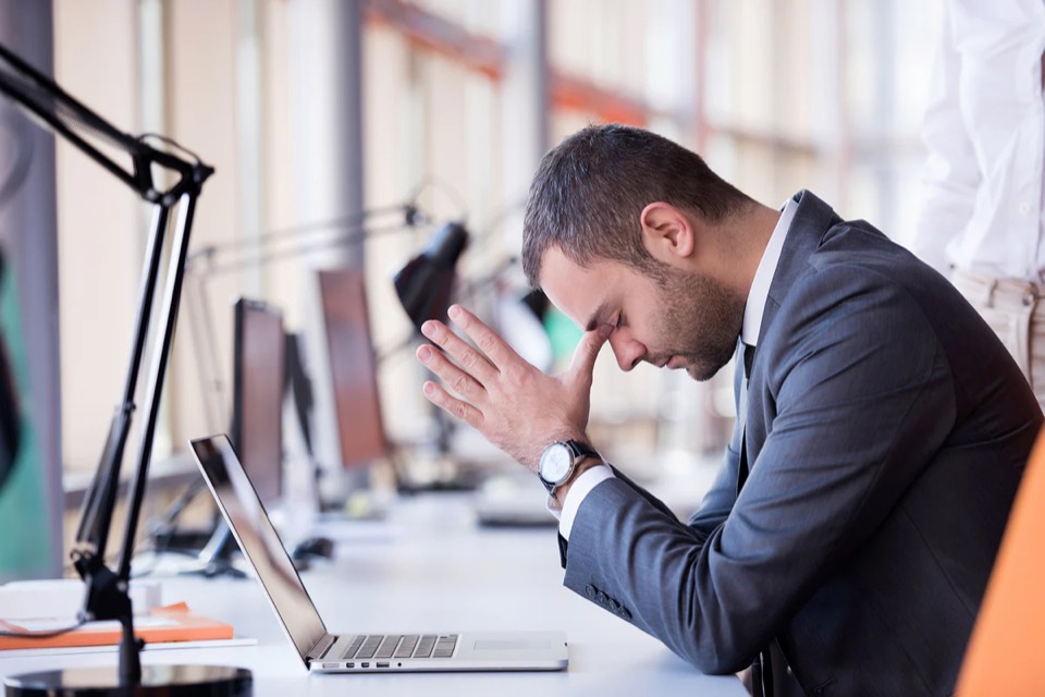 A professional in a quiet moment of pressure — suggestive of work-stress and coping